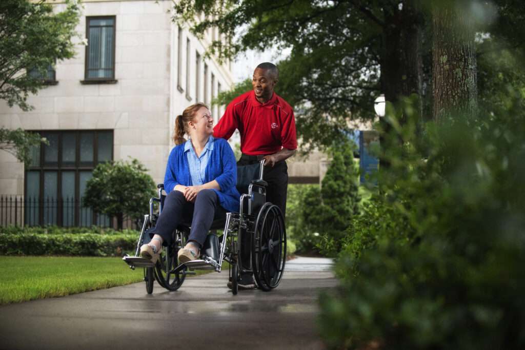 SP+ employee pushing guest in wheelchair