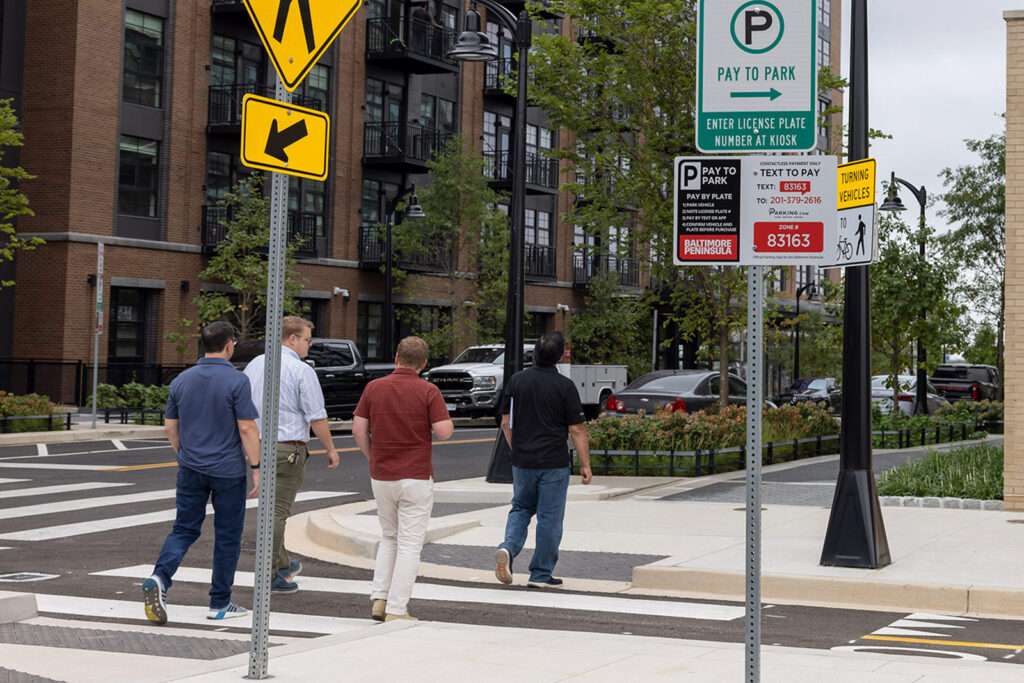 Personnes traversant la rue près des panneaux de stationnement